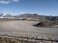 a winding cobbled walkway with blue railings to the side of a mountainous area