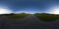 a winding road with grassy hills in the background in a fisheye image taken by 360 lens