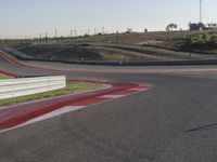 an empty track at a motorsports club with some red and white stripeing on it