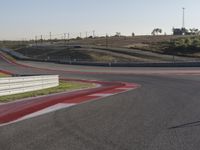 an empty track at a motorsports club with some red and white stripeing on it