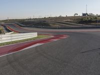 an empty track at a motorsports club with some red and white stripeing on it