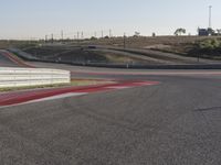 an empty track at a motorsports club with some red and white stripeing on it