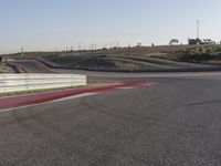 an empty track at a motorsports club with some red and white stripeing on it