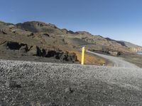 the winding road is in the desert with a yellow sign for traffic ahead of it