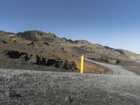 the winding road is in the desert with a yellow sign for traffic ahead of it