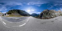 360 - lens photograph of a winding road in the mountains, taken from a low perspective