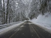 Winding Road Through Snowy Landscape with Mountains and Forest
