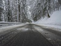 Winding Road Through Snowy Landscape with Mountains and Forest