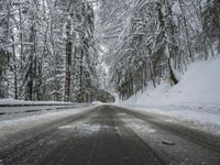 Winding Road Through Snowy Landscape with Mountains and Forest