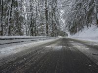 Winding Road Through Snowy Landscape with Mountains and Forest