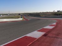 an empty track at a motorsports club with some red and white stripeing on it