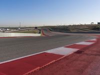 an empty track at a motorsports club with some red and white stripeing on it