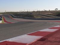 an empty track at a motorsports club with some red and white stripeing on it