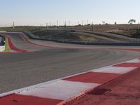 an empty track at a motorsports club with some red and white stripeing on it