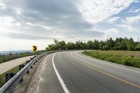 the road is winding towards an empty road and signs indicate where to go for it