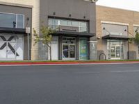 a large commercial store front with no parking at all along the street side and red curb