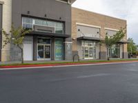 a large commercial store front with no parking at all along the street side and red curb