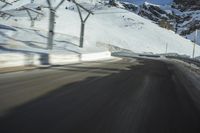 a blurry photo of a car driving down a snowy road with mountains in the background