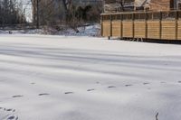 a building and fence covered in snow next to a street side walk and several tall buildings