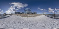 a fisheye lens is shown in the snow on the beach near a bridge,