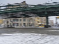 a blurry photo of a bus traveling underneath a bridge over water and snow on the street