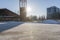 a church with snow on the ground and a big clock tower standing in front of it