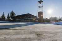 a church with snow on the ground and a big clock tower standing in front of it