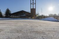 a church with snow on the ground and a big clock tower standing in front of it