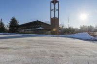 a church with snow on the ground and a big clock tower standing in front of it