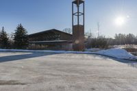 a church with snow on the ground and a big clock tower standing in front of it