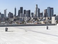 a man with black jacket skateboarding on cement outside of a building with city skyline in background