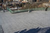 a view of the town in winter from a roof top balcony of a building with a wrought fence in front