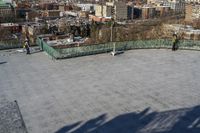 a view of the town in winter from a roof top balcony of a building with a wrought fence in front