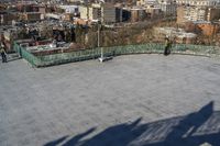 a view of the town in winter from a roof top balcony of a building with a wrought fence in front