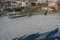 a view of the town in winter from a roof top balcony of a building with a wrought fence in front