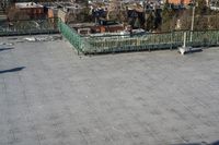 a view of the town in winter from a roof top balcony of a building with a wrought fence in front