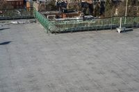 a view of the town in winter from a roof top balcony of a building with a wrought fence in front