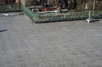 a view of the town in winter from a roof top balcony of a building with a wrought fence in front