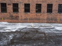 an old red brick building that has no windows and no fire hydrant or sidewalk