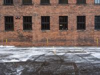 an old red brick building that has no windows and no fire hydrant or sidewalk