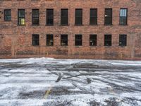 an old red brick building that has no windows and no fire hydrant or sidewalk