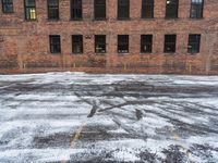 an old red brick building that has no windows and no fire hydrant or sidewalk