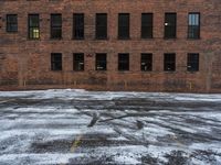 an old red brick building that has no windows and no fire hydrant or sidewalk