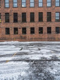 an old red brick building that has no windows and no fire hydrant or sidewalk