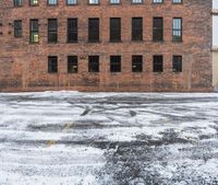 an old red brick building that has no windows and no fire hydrant or sidewalk