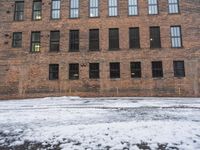 an old red brick building that has no windows and no fire hydrant or sidewalk