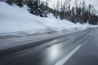 a car is driving on the snow covered road in the winter hours of this time of day