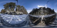 two snow covered roads in a snow - filled forest area and a blue sky behind