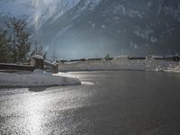 a black snow covered road in the mountains in the snow, as if for driving down a mountain