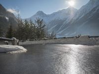 a black snow covered road in the mountains in the snow, as if for driving down a mountain